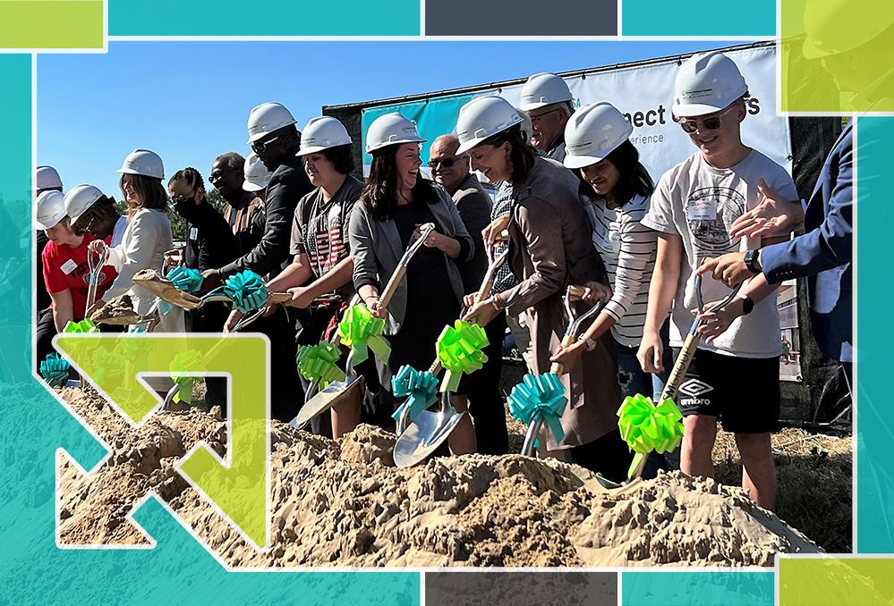  People line up during groundbreaking ceremony with shovels and hard hats. 